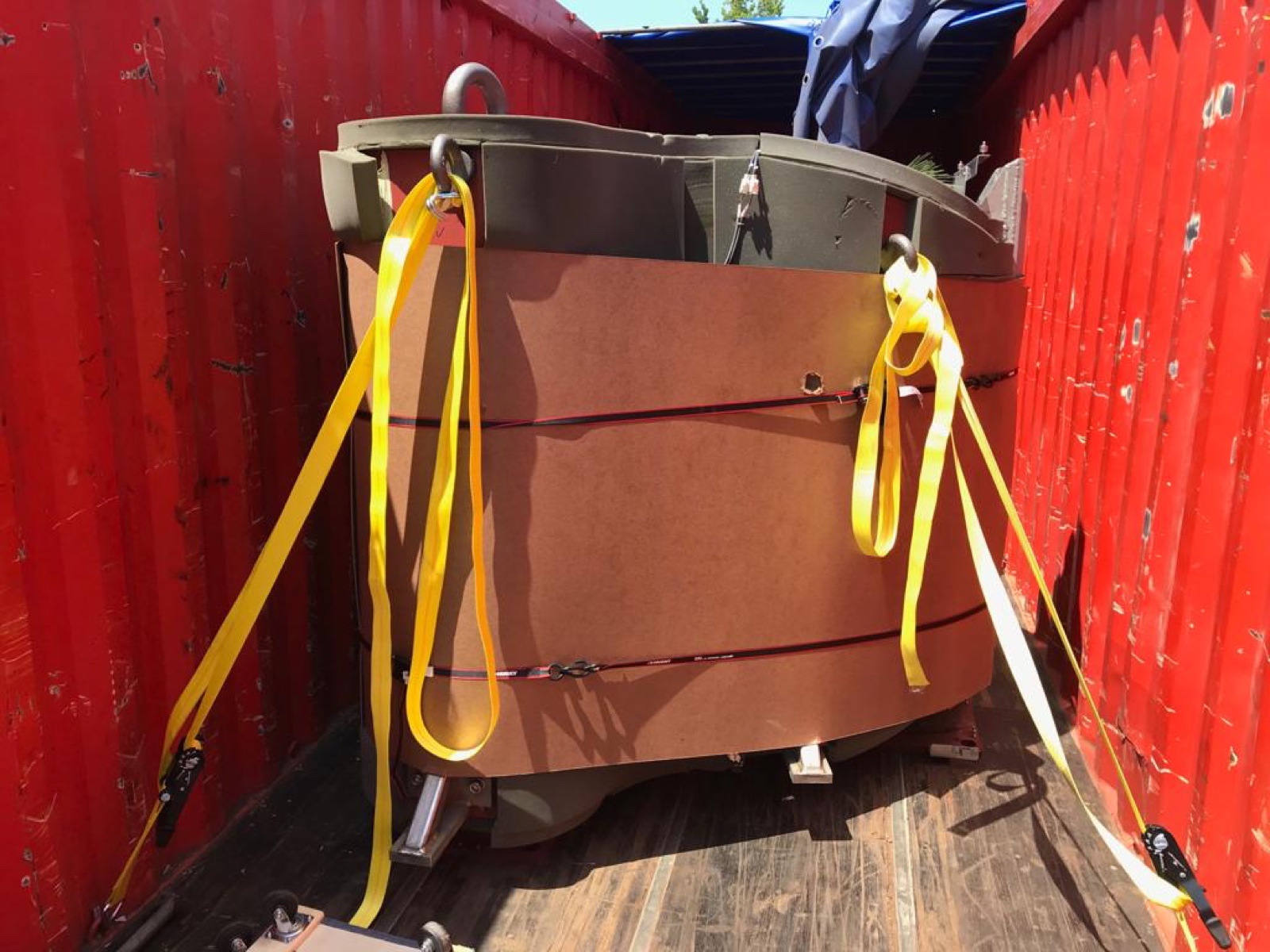 Open MRI magnet being crane-loaded during controlled equipment removal.